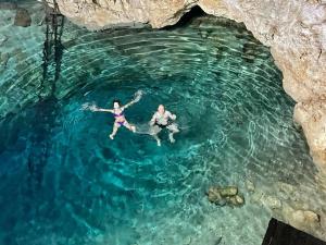 two people swimming in the water in a cave at Surrounded by Cenotes, Mayan sites and Haciendas in Seyé