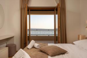 a bedroom with a bed with a view of the ocean at Apartments Lea in Podstrana