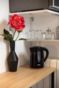 eine rote Rose in einer schwarzen Vase auf einem Tisch in der Unterkunft My Way room, parking, sea view, terrace in Rijeka