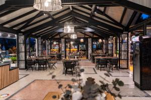 un restaurant avec des tables, des chaises et des lustres dans l'établissement Blue Star Hotel, à Ölüdeniz