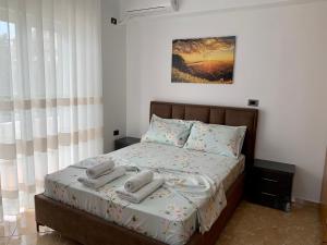 sypialnia z łóżkiem z ręcznikami w obiekcie Maxus Apts w Sarandzie