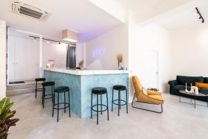 una sala de estar con un bar con taburetes en Play Psyri Athens, en Atenas