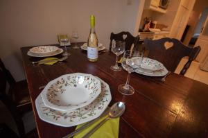 a table with plates and glasses and a bottle of wine at Castle Hillside Apartment in Budapest