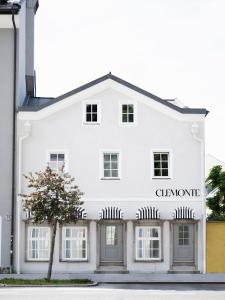 un edificio blanco con un árbol delante en Clemonte Hotel - Your Reception-less Boutique Hideaway en Salzburgo
