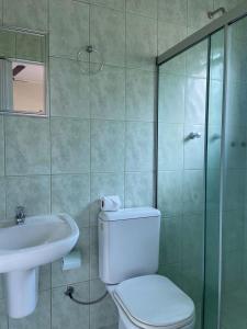 een badkamer met een toilet, een wastafel en een douche bij Pousada Dois Irmãos in Trindade