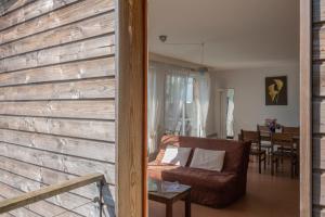 sala de estar con pared de madera y sofá en Domaine de Saint Orens - Résidence de vacances - Montréal du Gers, en Montréal