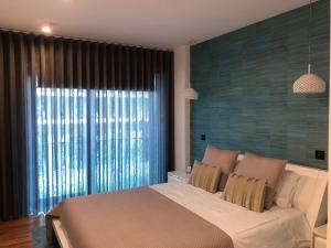フンシャルにあるAstro Madeira Apartmentsのベッドルーム(大型ベッド1台、大きな窓付)