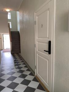 a hallway with a white door and a checkered floor at Võru Studio Apartment in Võru