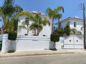 a white house with palm trees in front of it at Villa Diana - 200 meters from Kapparis, Fireman's Beach in Paralimni