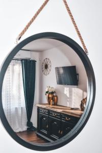 espejo que refleja una habitación con tocador y TV en Villa-Apartments Bognar en Velika