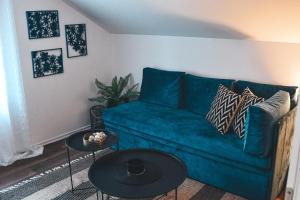 a living room with a blue couch and two tables at Villa-Apartments Bognar in Velika