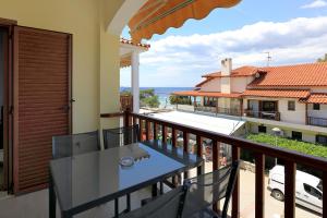 a balcony with a table and a view of a house at Agapitos Apartments in Nikiti