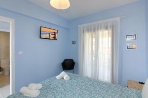 a blue bedroom with two towels on a bed at Agapitos Apartments in Nikiti