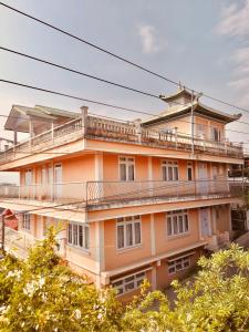 ein orangefarbenes Gebäude mit Balkon darüber in der Unterkunft SEWANS PLACE Homestay in Mirik