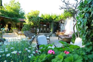 a patio with chairs and flowers in a garden at Dardanos Hotel in Patara