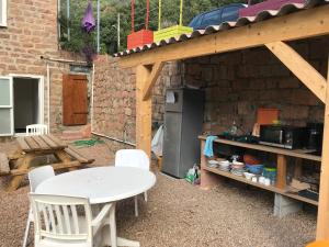 a patio with a white table and chairs and a kitchen at Hôtel Colombo- Porto Corse in Porto Ota