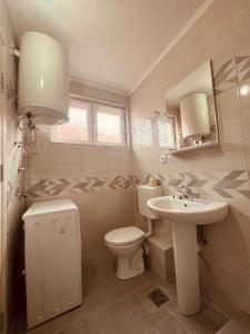 毛茛的住宿－SNAM Rooms&Apartment，白色的浴室设有卫生间和水槽。