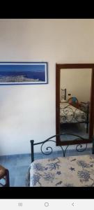 a bedroom with two beds and a mirror at La casetta di Giovanna in Marettimo