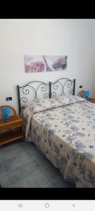 um quarto com uma cama com um cobertor e uma mesa em La casetta di Giovanna em Marettimo