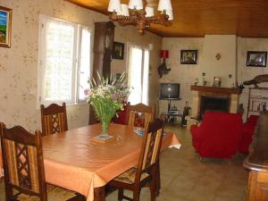 a dining room table with a vase of flowers on it at Gîte Saint Michel 2 étoiles in Moulin-Mage