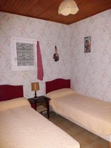 a room with two beds and a table with a lamp at Gîte Saint Michel 2 étoiles in Moulin-Mage