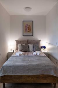 1 dormitorio con 1 cama grande con almohadas en Lido Riviéra 011 Apartman en Balatonlelle