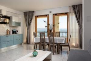 a kitchen and dining room with a table with a view at Apartments Lea in Podstrana