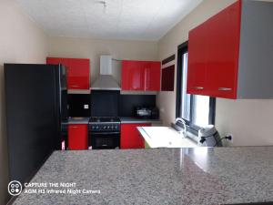 una cucina con armadi rossi e frigorifero nero di Villas Manguier ou Villa Poivriers a Saint-Pierre