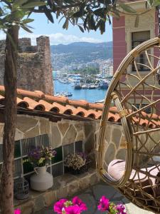 a wicker chair sitting on a balcony overlooking a harbor at Villa Aurelia Old Town in Kavala