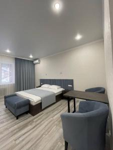 um quarto com 2 camas, uma mesa e cadeiras em JETISY COMPLEX em Taraz