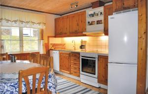 a kitchen with a white refrigerator and a table at Amazing Home In Segmon With Sauna in Kangerud