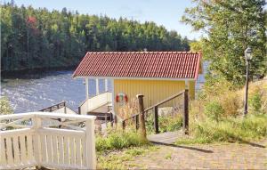 a small yellow building next to a river at Amazing Home In Segmon With Sauna in Kangerud