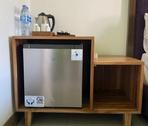 - un petit réfrigérateur dans une armoire en bois avec une étagère dans l'établissement Dikubu Belong Seminyak, à Seminyak