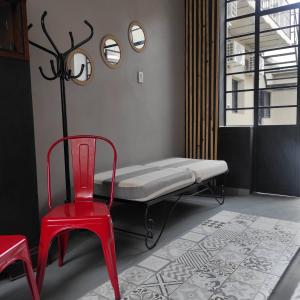 una silla roja y una cama en una habitación en HOME espacios 1 en Santa Fe