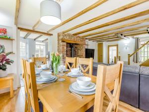 een eetkamer en een woonkamer met een houten tafel en stoelen bij The Tumbling Sailor in Ironbridge