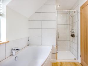 een witte badkamer met een bad en een douche bij The Tumbling Sailor in Ironbridge