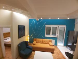 a living room with a couch and a blue wall at Apartment Nikirent in Banja Luka