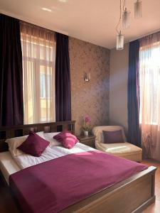 a bedroom with a large bed with a purple blanket at Vidin Hotel in Vidin