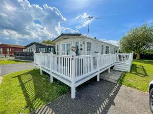 una casa blanca con una valla blanca en un patio en Beautiful Caravan At Manor Park In Hunstanton Beach, Norfolk Ref 23026h en Hunstanton