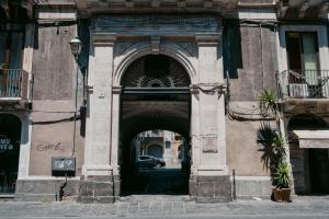 łuk w budynku z samochodem przejeżdżającym przez niego w obiekcie La Casa di Alma Luxury rooms w Katanii