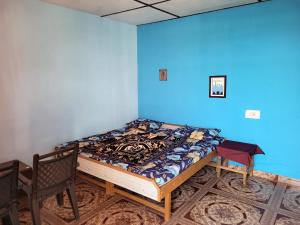 Cama en habitación con pared azul en Namaste Bhagsu - Rooms & Rooftop Cafe en Dharamshala