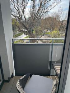 a balcony with a chair and a view of a tree at APARTMENT A&D Downtown in Poprad