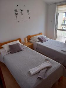 twee bedden naast elkaar in een slaapkamer bij Apartmani Krpeta in Pakoštane