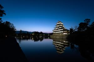 松本市にあるPopotel 2 KURAの夜の湖上の中国建築