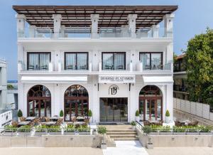 een gevel van een wit gebouw met ramen bij Diverso Platamon, Luxury Hotel & Spa in Platamonas