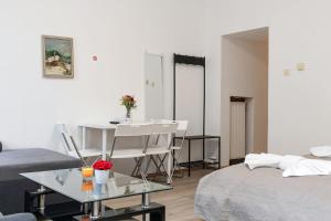 a living room with a bed and a table and chairs at Spacious & Pleasent 2BR Apt. near Milenium Tower in Vienna