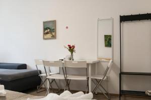 a living room with a table and chairs and a bed at Spacious & Pleasent 2BR Apt. near Milenium Tower in Vienna