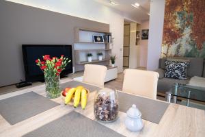 ein Wohnzimmer mit einem Tisch mit Obst und Blumen darauf in der Unterkunft Stawowa Premium Apartment - 69 m2 with sauna and private garage in Krakau