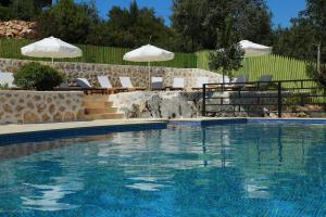 a swimming pool with chairs and umbrellas in a yard at Dardanos Hotel in Patara