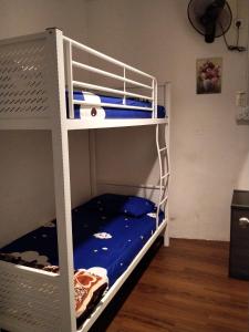 a bedroom with two bunk beds with blue sheets at JOKA-JOKA GUESTHOUSE in Melaka